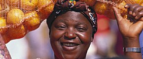 Femme africaine, portant des oranges sur sa tête 